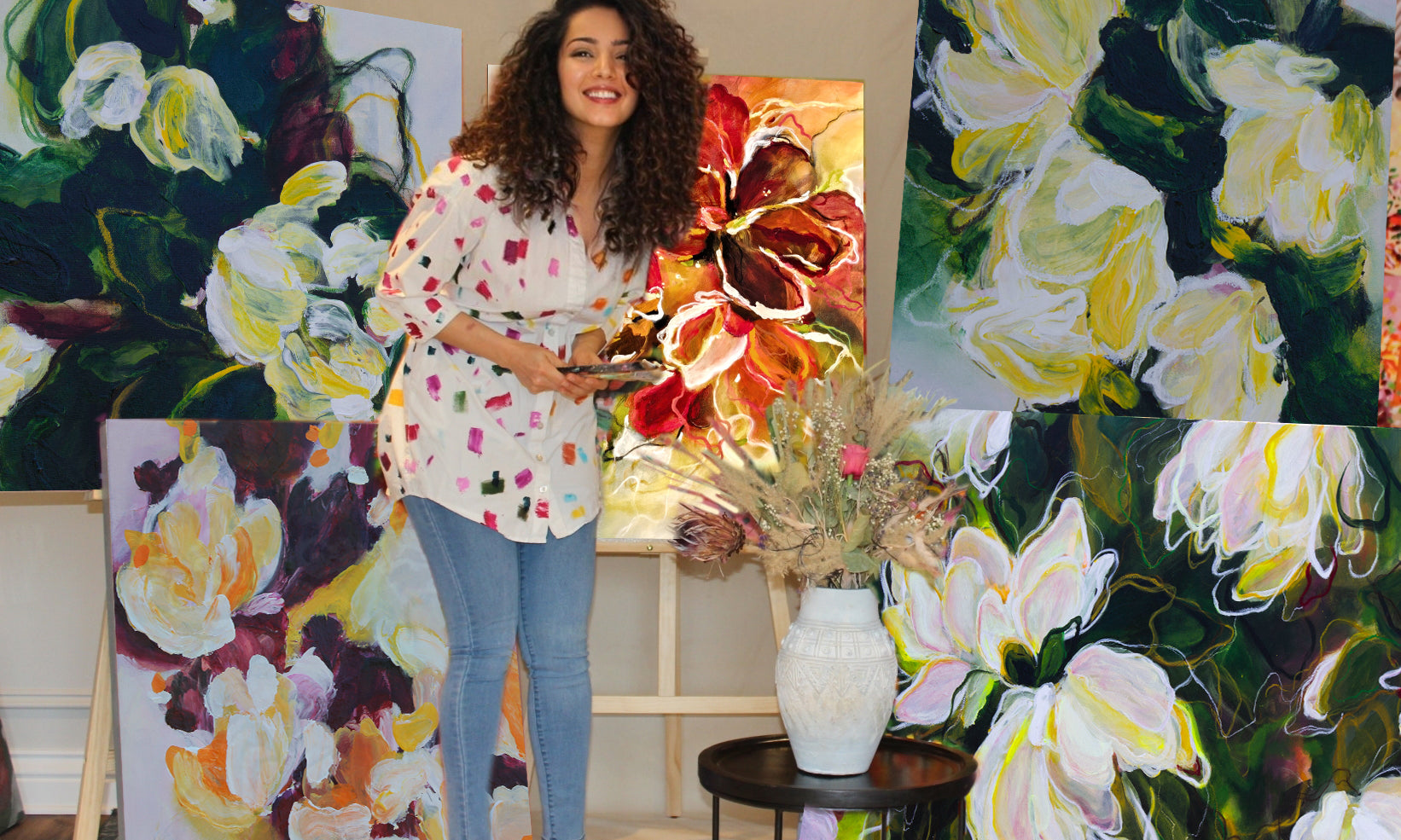 Mona, the artist behind the brand Mona Atiye in her studio surrounded by her original botanical floral abstract paintings