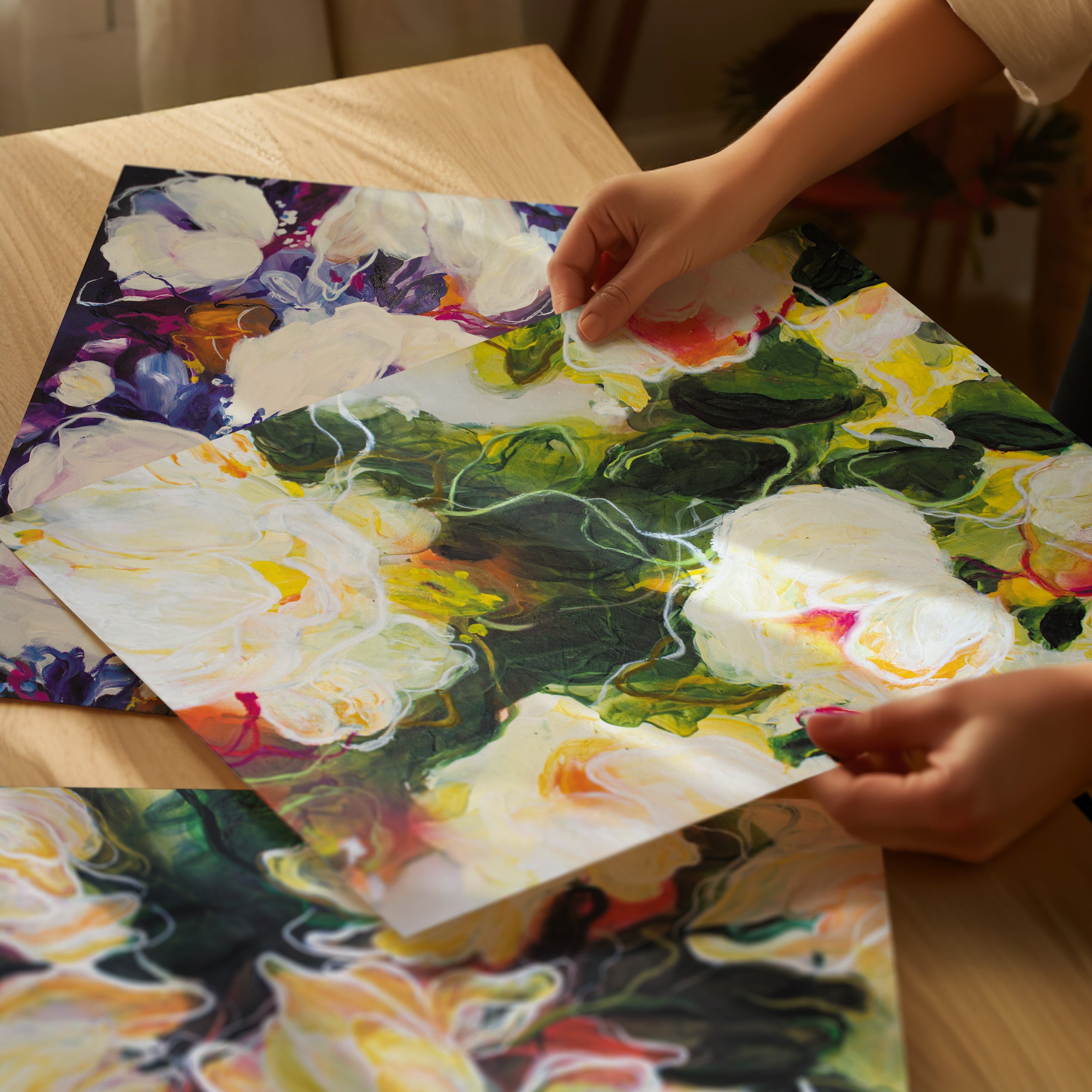 Person assembling a floral puzzle on a wooden table