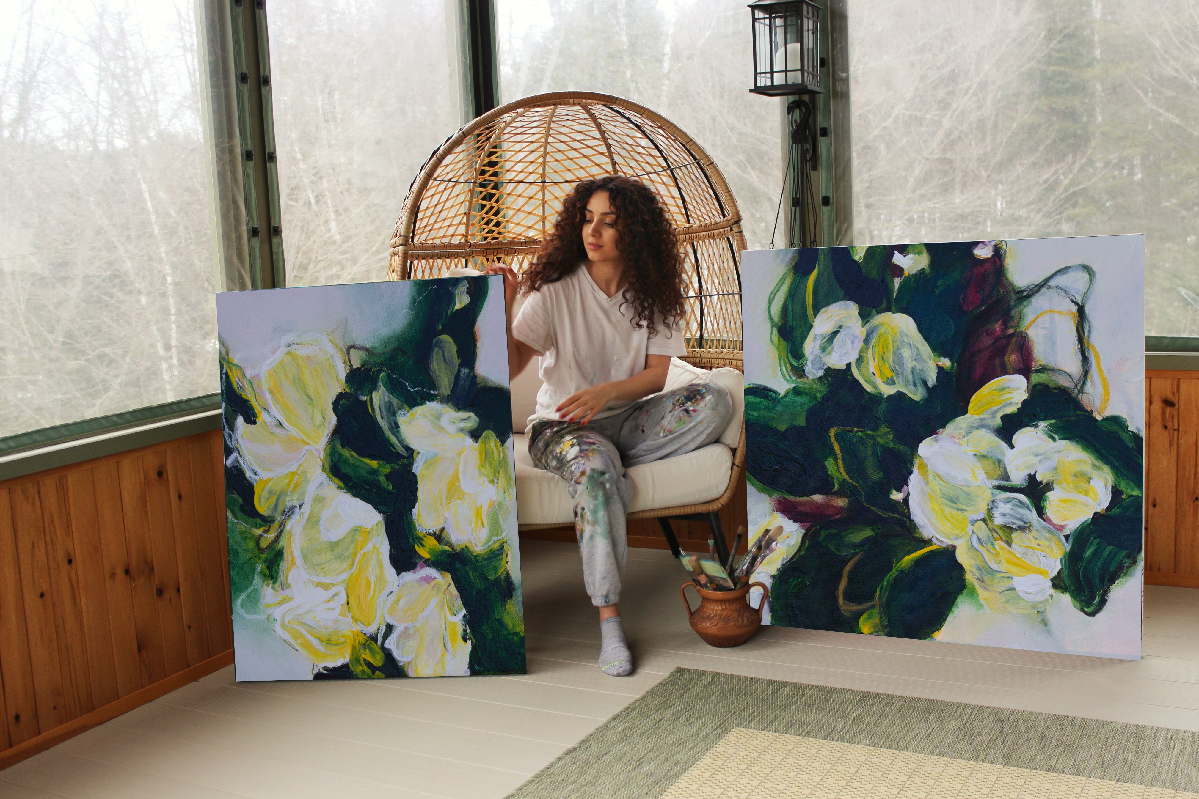 An image of the artist Mona with two of her canvas prints of her original artwork of botanical floral abstract art