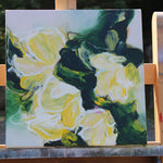 Painting of yellow flowers on a wooden easel outdoors
